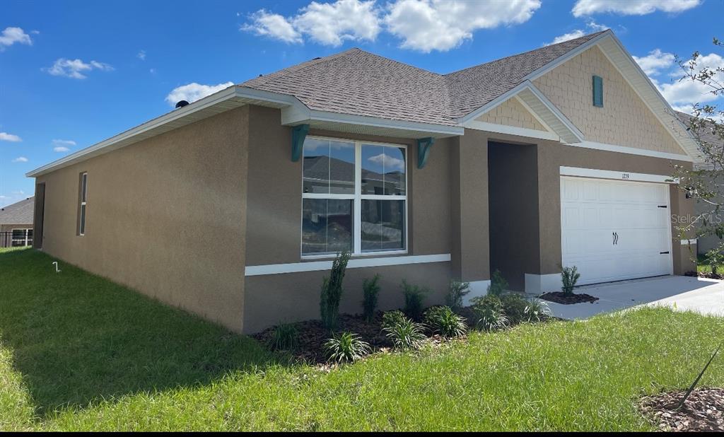 1779 Buckeye Road Davenport, FL 33837 - Photo 2 of 20 a front view of a house with garden