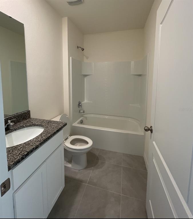 1779 Buckeye Road Davenport, FL 33837 - Photo 8 of 20 a bathroom with a granite countertop bathtub shower sink and toilet