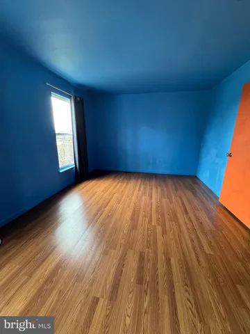 a view of a room with wooden floors and window