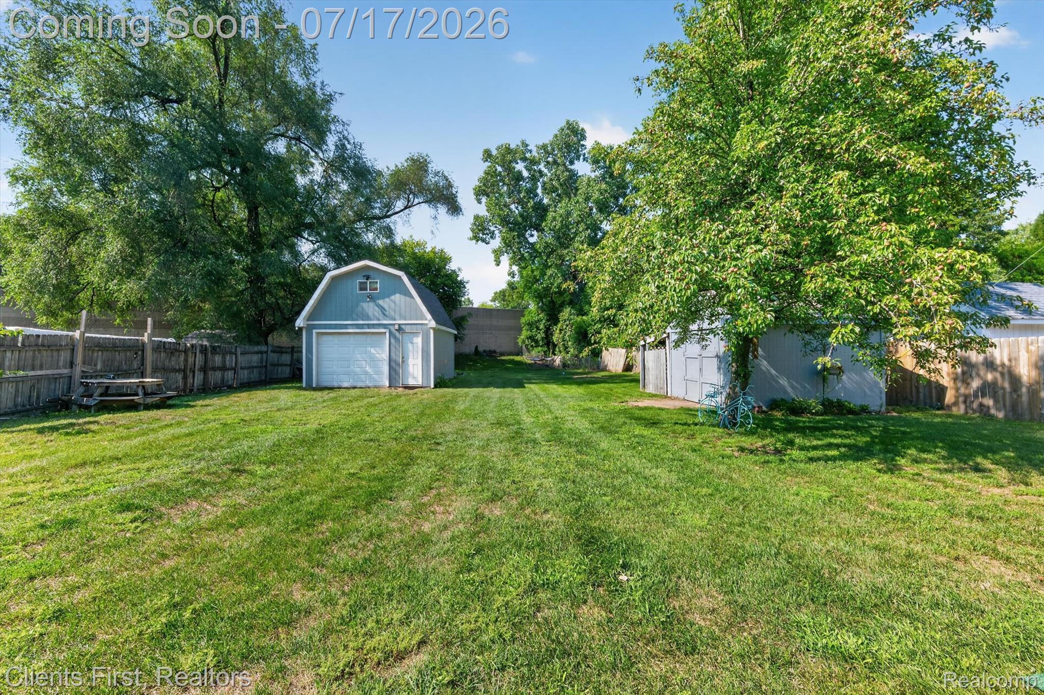 36852 Chase Street Romulus, MI 48174 - Photo 36 of 40 Expansive green lawn with a detached garage featuring a gambrel roof and overhead door