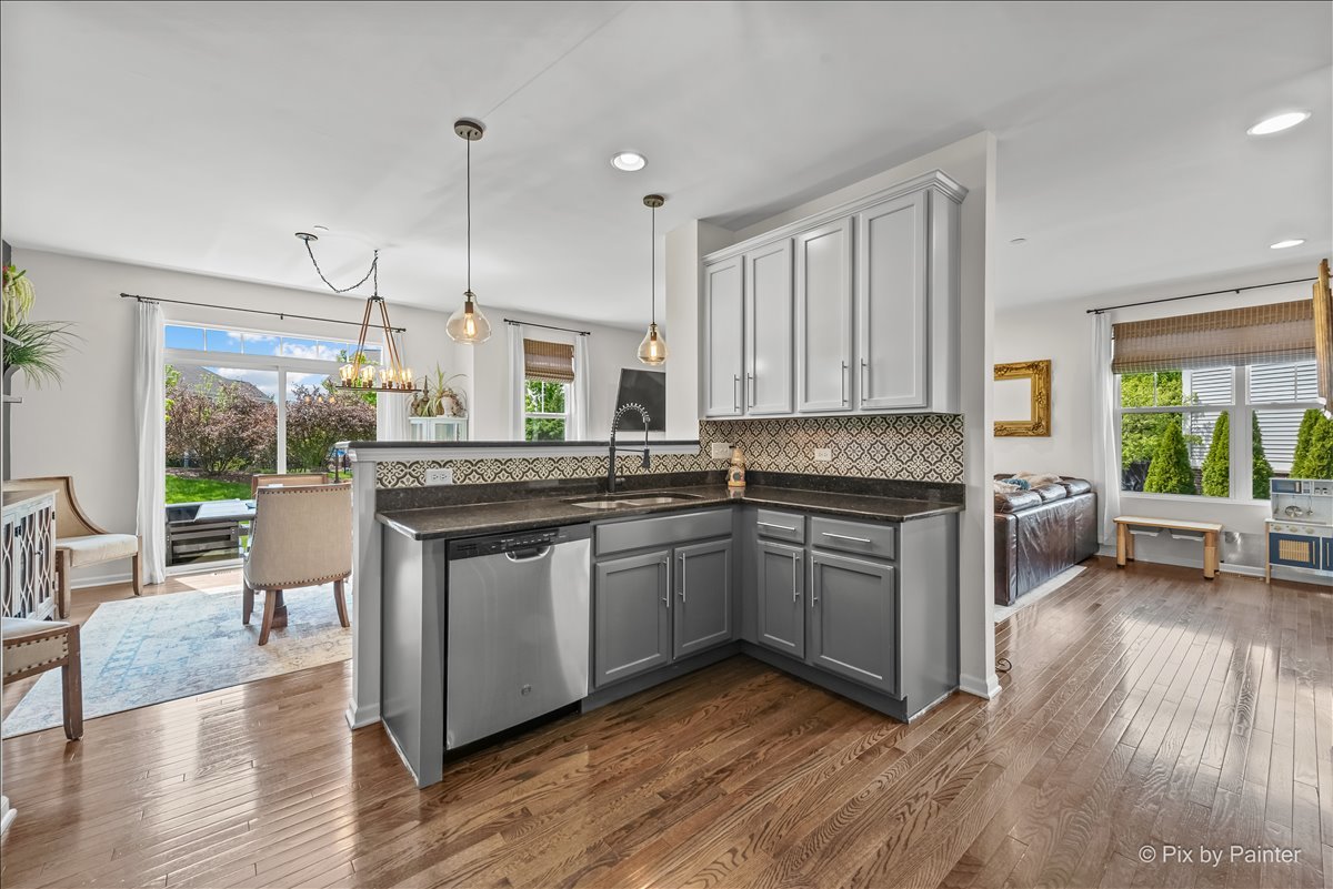 16207 West Switch Grass Road Lockport, IL 60441 - Photo 14 of 45 a kitchen with stainless steel appliances granite countertop wooden floors and white cabinets