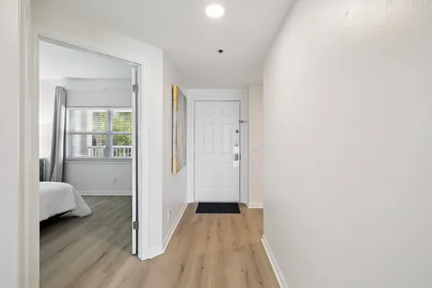 a view of a bedroom with wooden floor and furniture