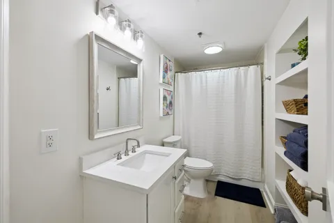 a bathroom with a sink a toilet and a mirror