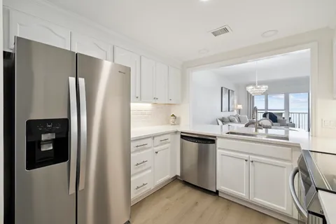 a kitchen with white cabinets and stainless steel appliances