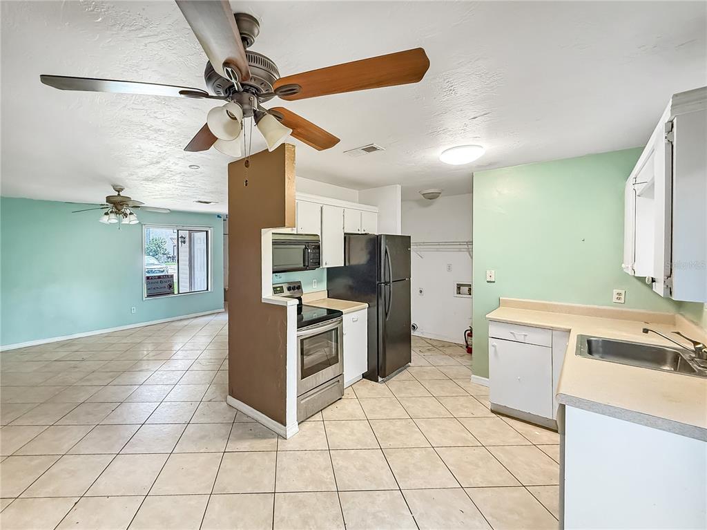 322 Canal Road, Unit G41 Edgewater, FL 32132 - Photo 4 of 14 a kitchen with a stove a sink and a refrigerator