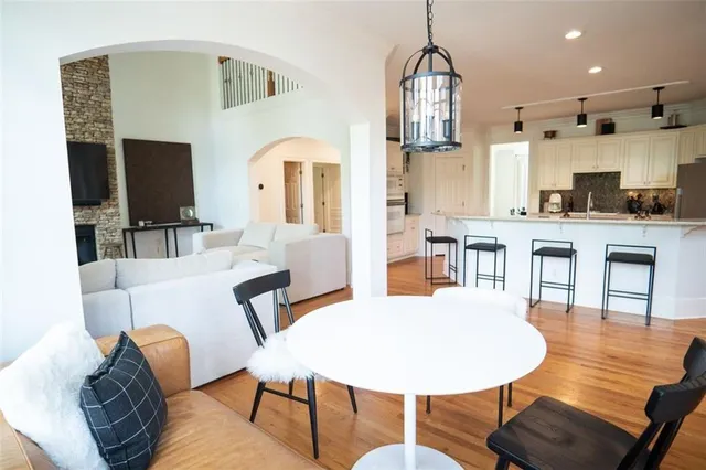 a living room with furniture a flat screen tv and kitchen view