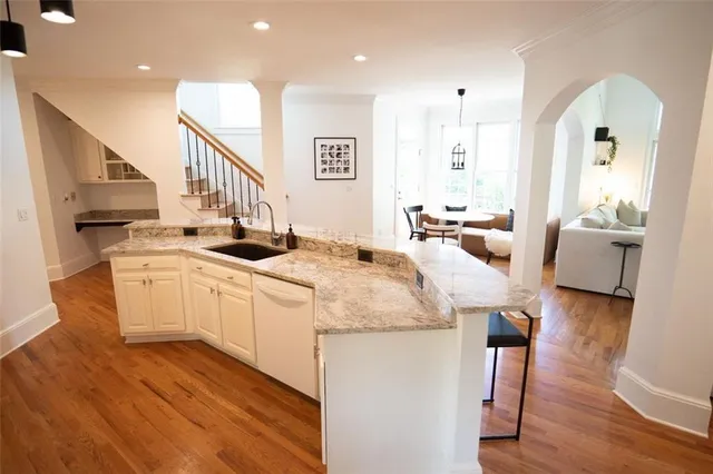 a open kitchen with kitchen island a white counter space a sink appliances and cabinets