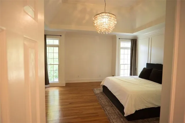 a bedroom with a large bed and a chandelier