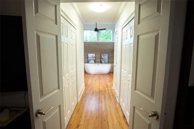 a view of a hallway with wooden floor and cabinet