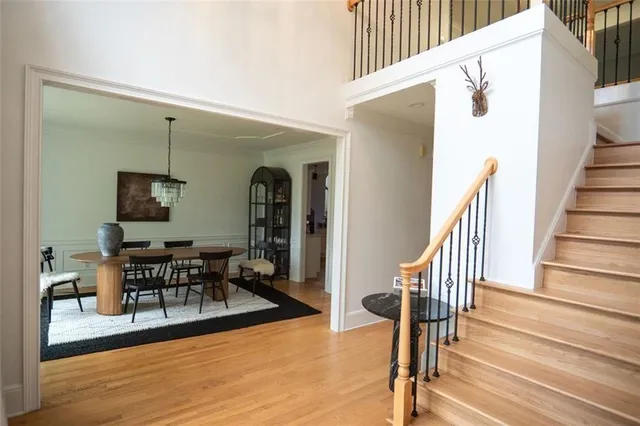 a view of a hallway with couches and dining table with wooden floor