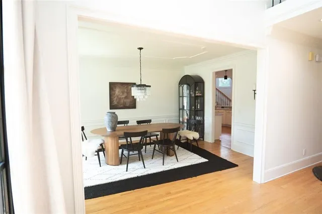 a view of a dining hall with a dining table chairs and couches with wooden floor