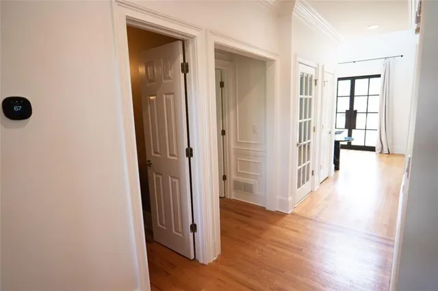 a view of a hallway with wooden floor and closet
