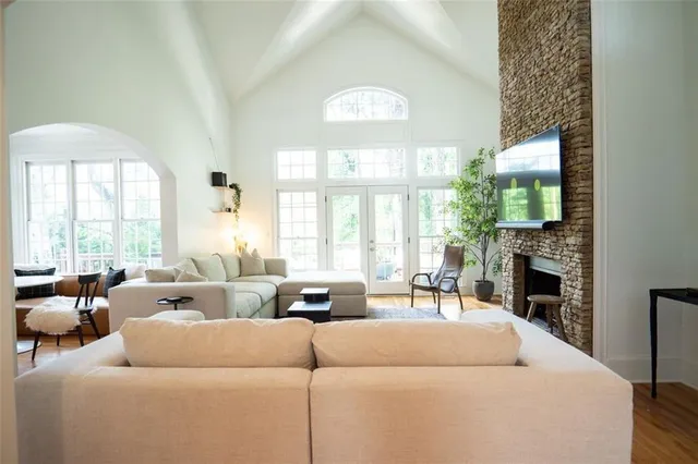a living room with furniture a large window and a fireplace
