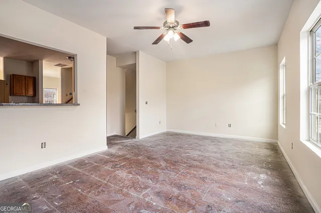 a view of a livingroom with a ceiling fan and window
