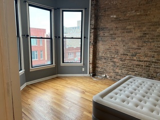 1215 West Grand Avenue, Unit 3F Chicago, IL 60642 - Photo 6 of 15 a view of an empty room and window