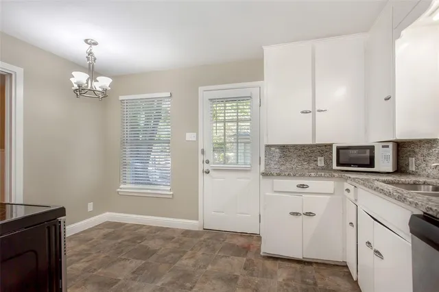 a kitchen that has a lot of cabinets and a wooden floor