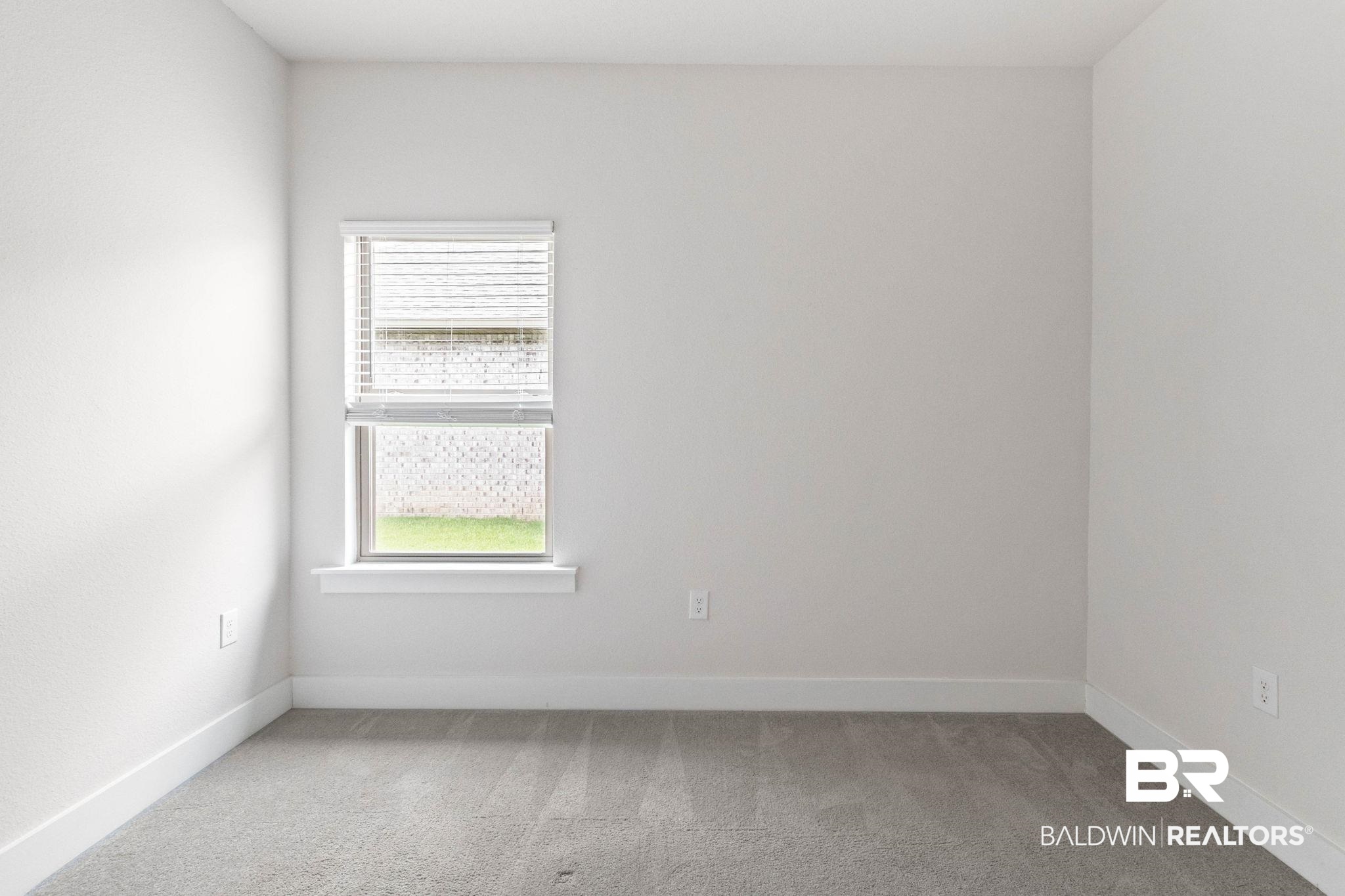 1710 Grouse Street Foley, AL 36535 - Photo 50 of 76 Neutral-toned room featuring a single window with blinds, light gray carpet, and white baseboards