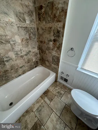 a bathroom with a tub and toilet