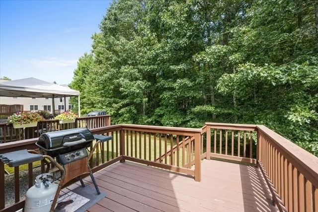 a view of a roof deck with wooden fence and trees