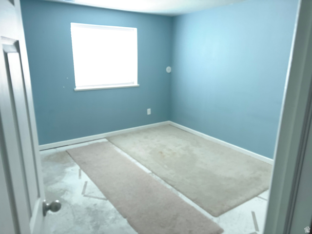 587 West 2400 South Perry, UT 84302 - Photo 41 of 46 Room with blue walls and a single window, featuring white trim and baseboards