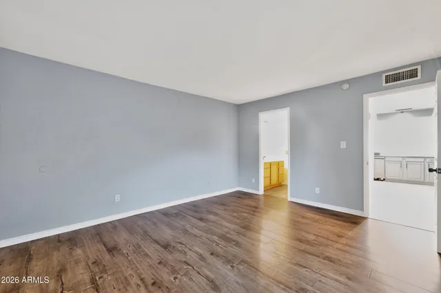 a view of empty room with wooden floor