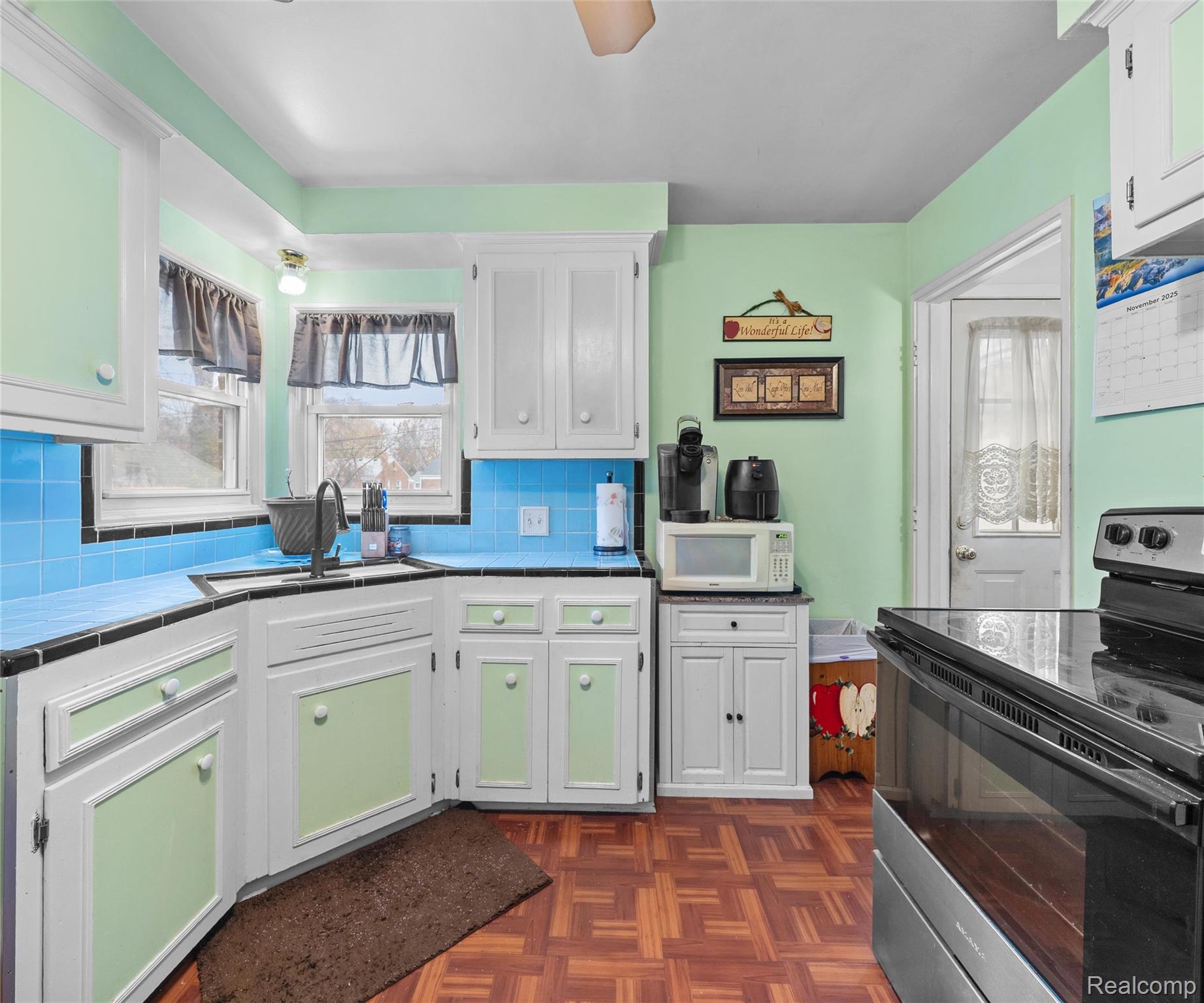 28940 Grandview Street Inkster, MI 48141 - Photo 20 of 41 Kitchen with stainless steel range with electric stovetop, white cabinetry, backsplash, and white microwave