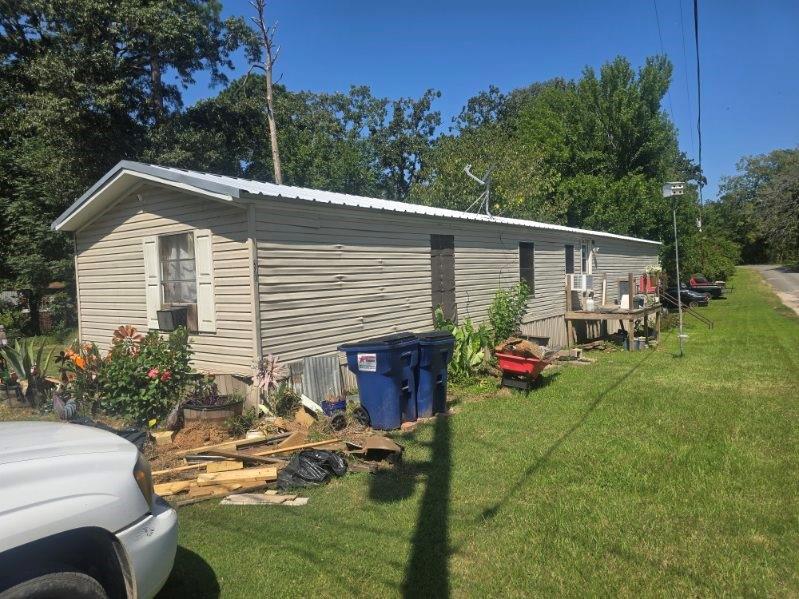 Single-story residence featuring light-colored horizontal siding and a metal roof