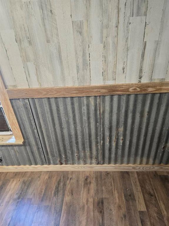 390 Campground Road Trinity, TX 75862 - Photo 12 of 37 Corrugated metal wainscoting with wood trim, complemented by wood-finish flooring and plank-style wall paneling