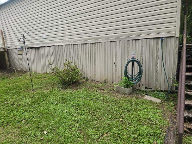 390 Campground Road Trinity, TX 75862 - Photo 13 of 37 Outdoor space featuring a hose reel with a coiled hose, a small concrete planter, and a green shrub
