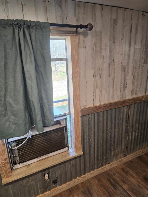 390 Campground Road Trinity, TX 75862 - Photo 23 of 37 Interior room featuring wood-finish flooring, a window with wood trim, and a wall with a mixed material finish