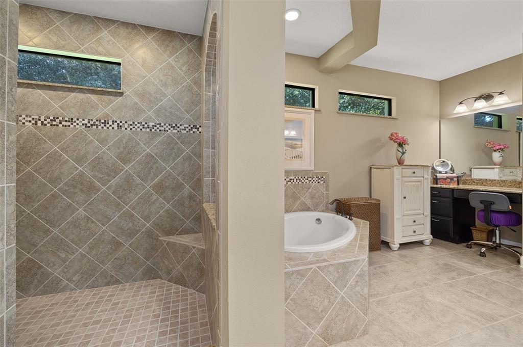 8692 Crested Eagle Place Sanford, FL 32771 - Photo 28 of 56 a bathroom with a tub sink and a mirror