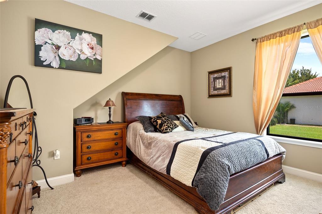 8692 Crested Eagle Place Sanford, FL 32771 - Photo 31 of 56 a bedroom with a bed and a painting on the wall