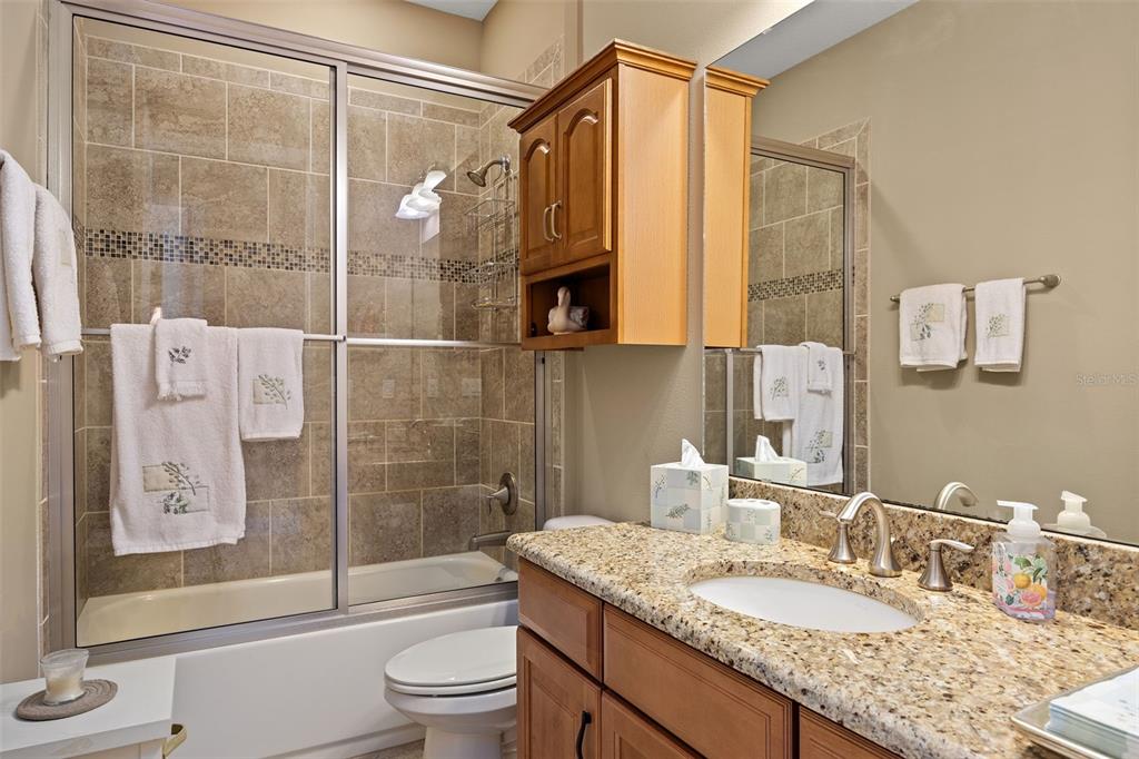 8692 Crested Eagle Place Sanford, FL 32771 - Photo 34 of 56 a bathroom with a granite countertop sink a toilet and shower
