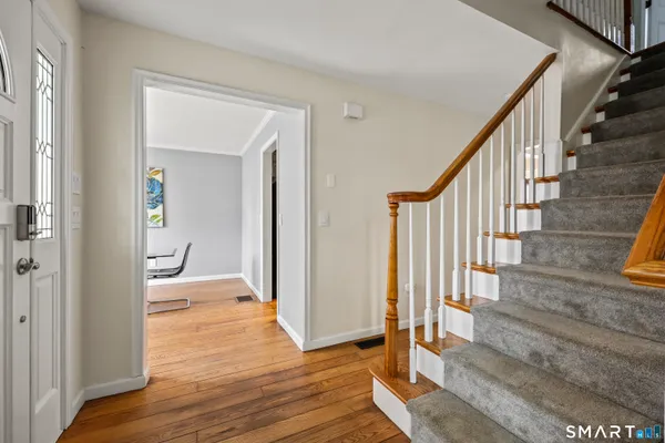 a view of a dining room with furniture a chandelier and wooden floor