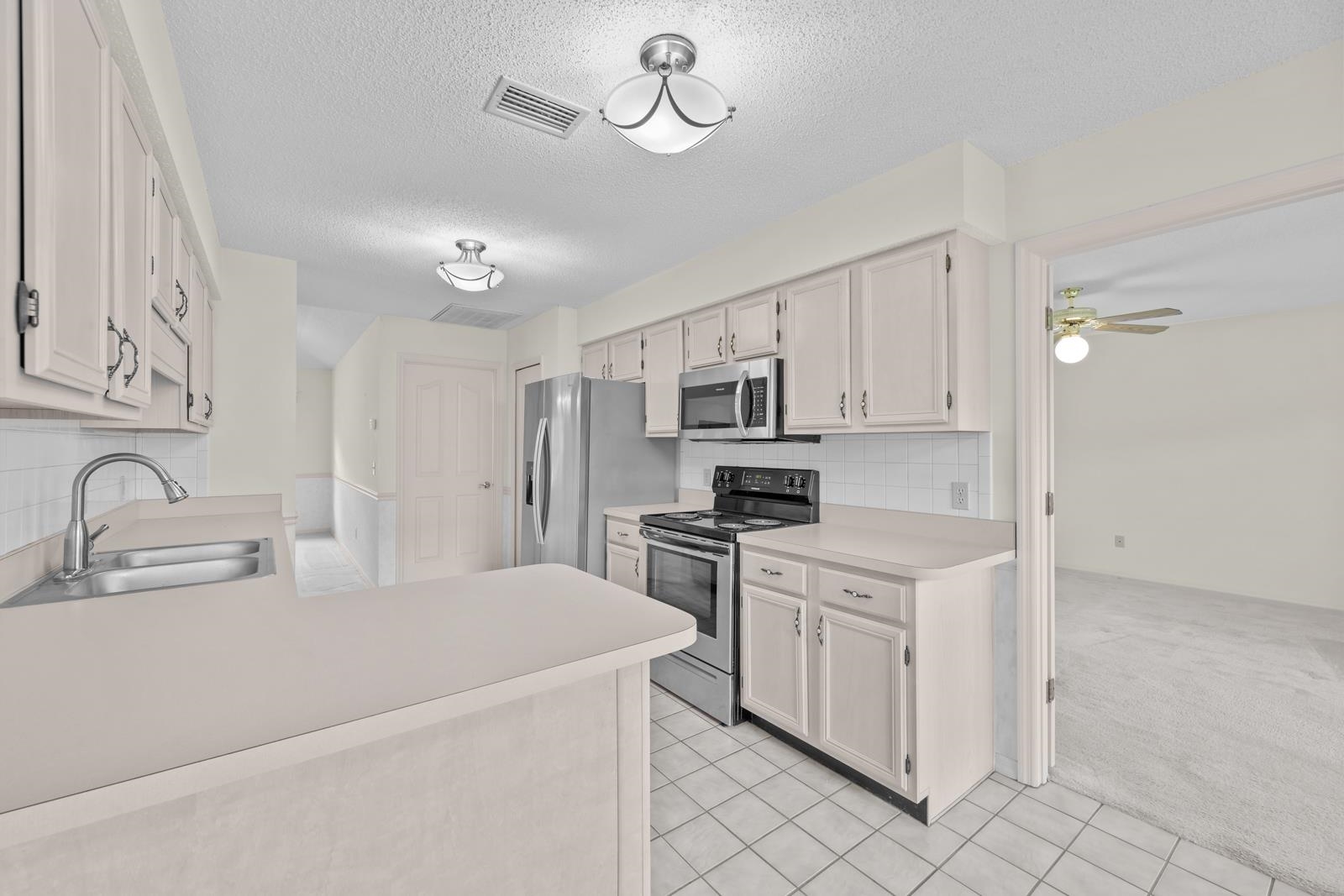 512 Moultrie Wells Road St. Augustine, FL 32086 - Photo 17 of 51 a kitchen with stainless steel appliances a sink stove and cabinets