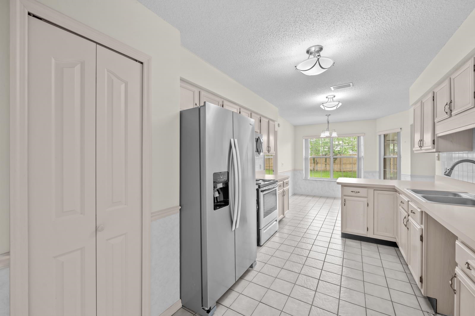 512 Moultrie Wells Road St. Augustine, FL 32086 - Photo 18 of 51 a large kitchen with a large window and stainless steel appliances