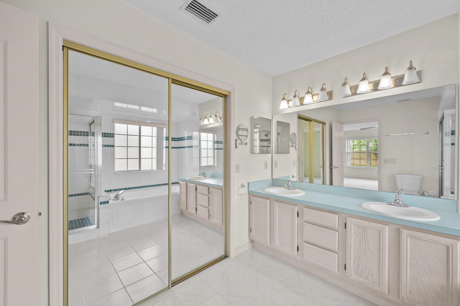 512 Moultrie Wells Road St. Augustine, FL 32086 - Photo 23 of 51 a spacious bathroom with a shower sink and mirror