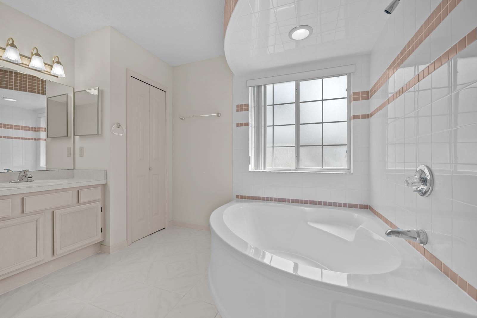 512 Moultrie Wells Road St. Augustine, FL 32086 - Photo 27 of 51 a bathroom with a tub a sink and a window