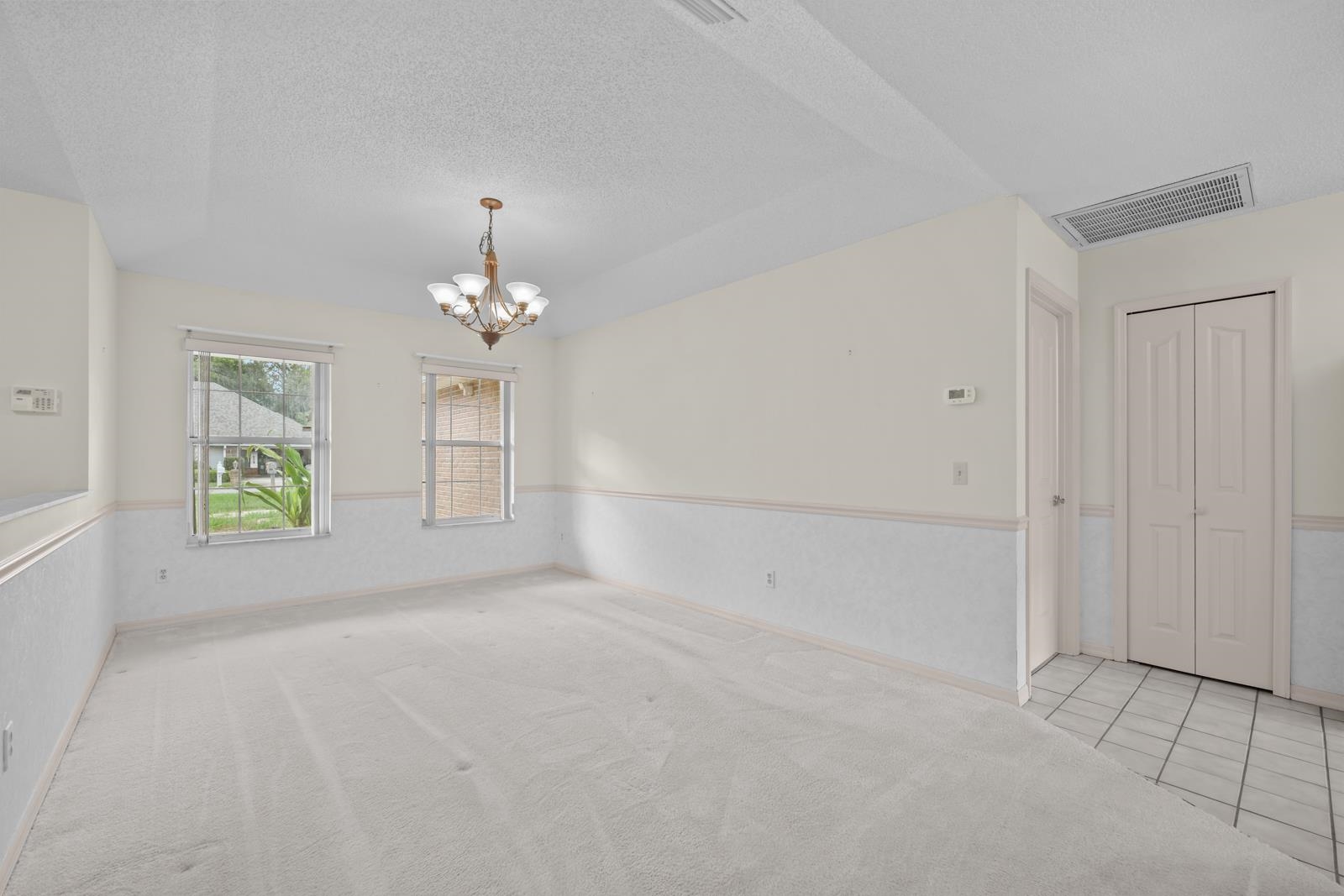 512 Moultrie Wells Road St. Augustine, FL 32086 - Photo 10 of 51 an empty room with windows and chandelier