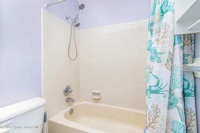 a white bath tub with a white curtain and a shower curtain