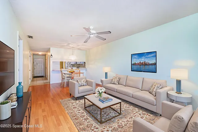 a living room with furniture and a wooden floor