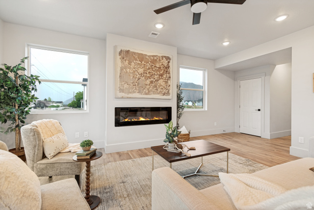 529 North Hvn Drive Mapleton, UT 84664 - Photo 7 of 30 Living area featuring a rectangular linear fireplace, wood-finish flooring, recessed lighting, and a ceiling fan