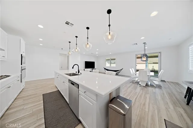 a view of a dining room with furniture a rug and wooden floor