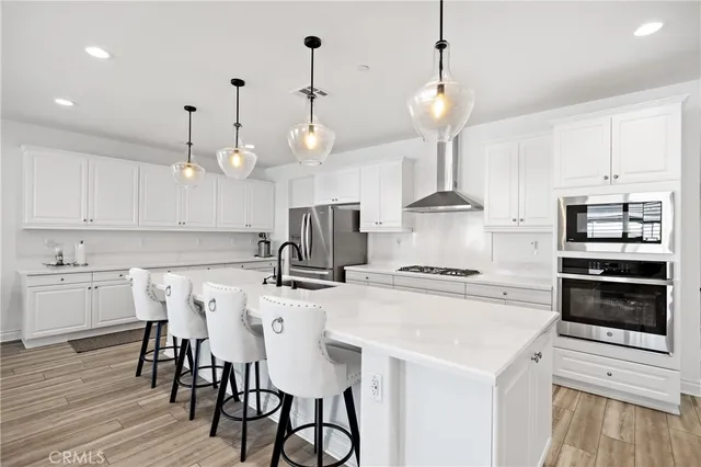 a kitchen with stainless steel appliances a stove a sink island and a refrigerator