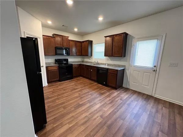 a large kitchen with stainless steel appliances kitchen island granite countertop a stove refrigerator and a sink