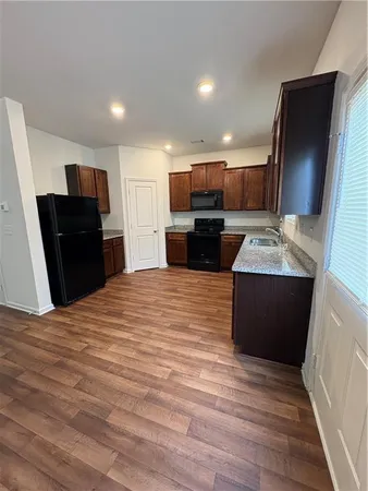 a large kitchen with kitchen island granite countertop a refrigerator and a sink