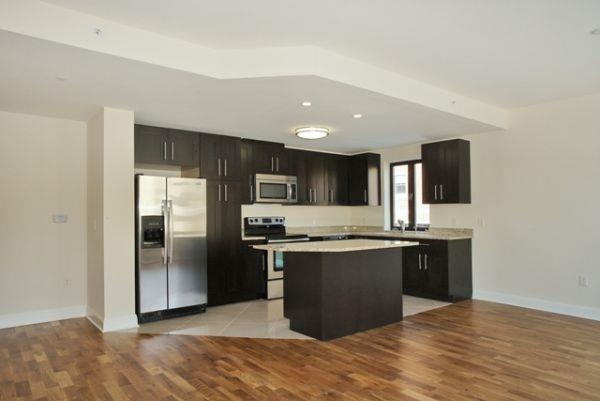 a kitchen with stainless steel appliances granite countertop a refrigerator and a stove top oven