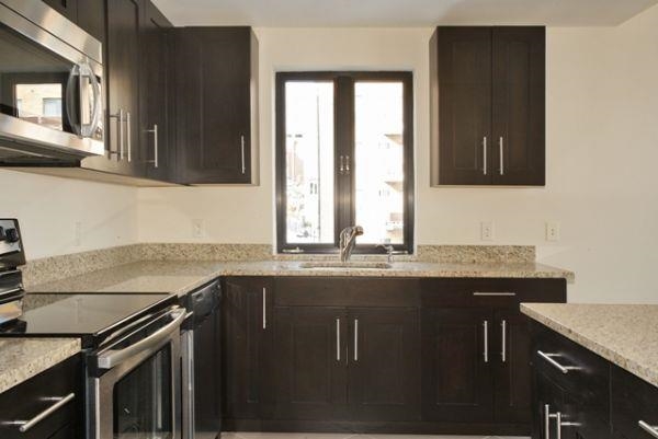 29 1st Street, Unit 607 Hackensack, NJ 07601 - Photo 4 of 13 a kitchen with granite countertop a sink stove and cabinets