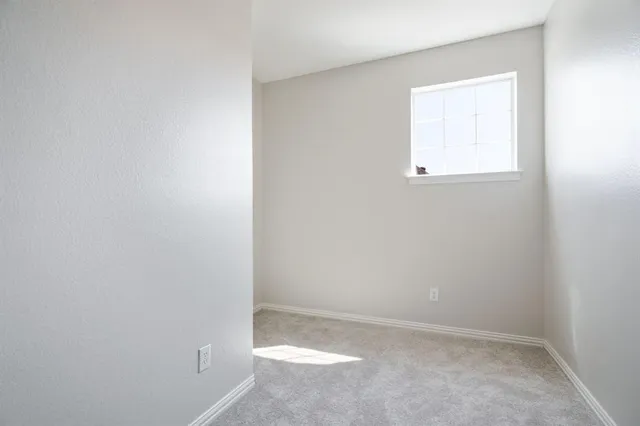 an empty room with a ceiling fan and a window