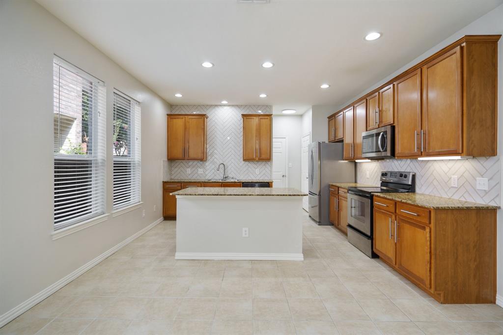 6407 Capulet Place Dallas, TX 75252 - Photo 5 of 33 a large kitchen with stainless steel appliances granite countertop a stove a sink and a refrigerator